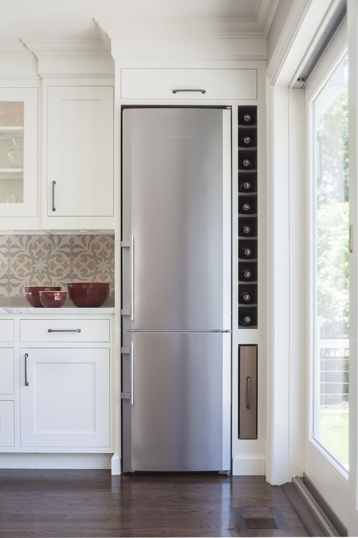 Холодильник у двери на кухне