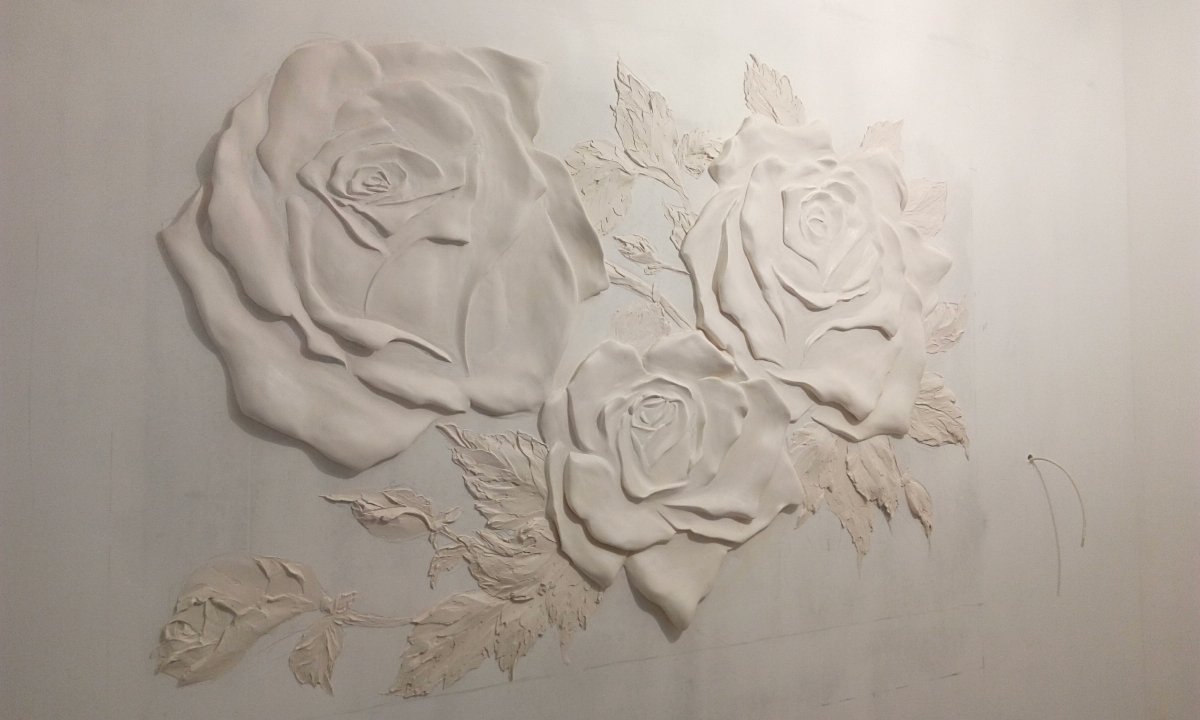 Розы из штукатурки на стене